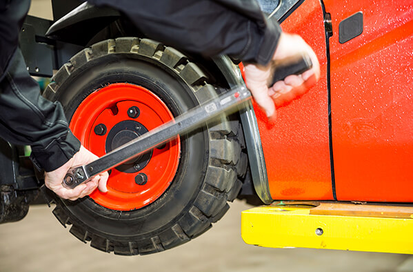 technician-replacing-the-front-drive-wheel-tyre-of-a-forklift-truck.jpg