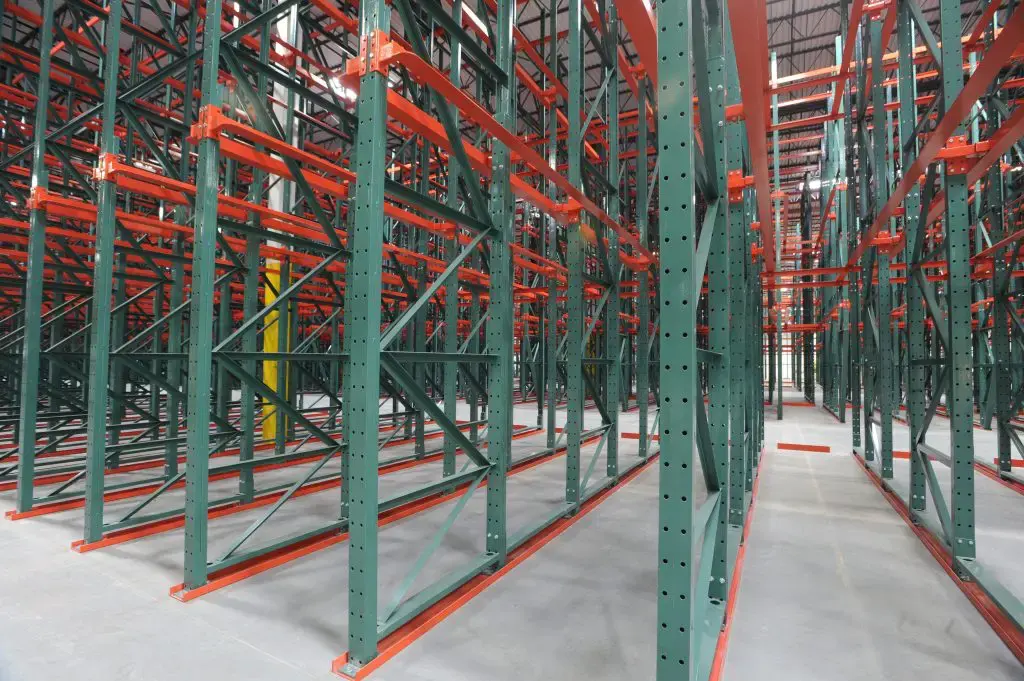 An empty drive through racking lane inside of a warehouse